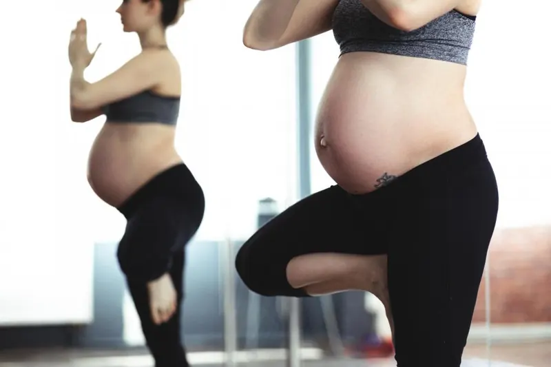 Dos mujeres embarazadas hacen un ejercicio de equilibrio sobre una pierna